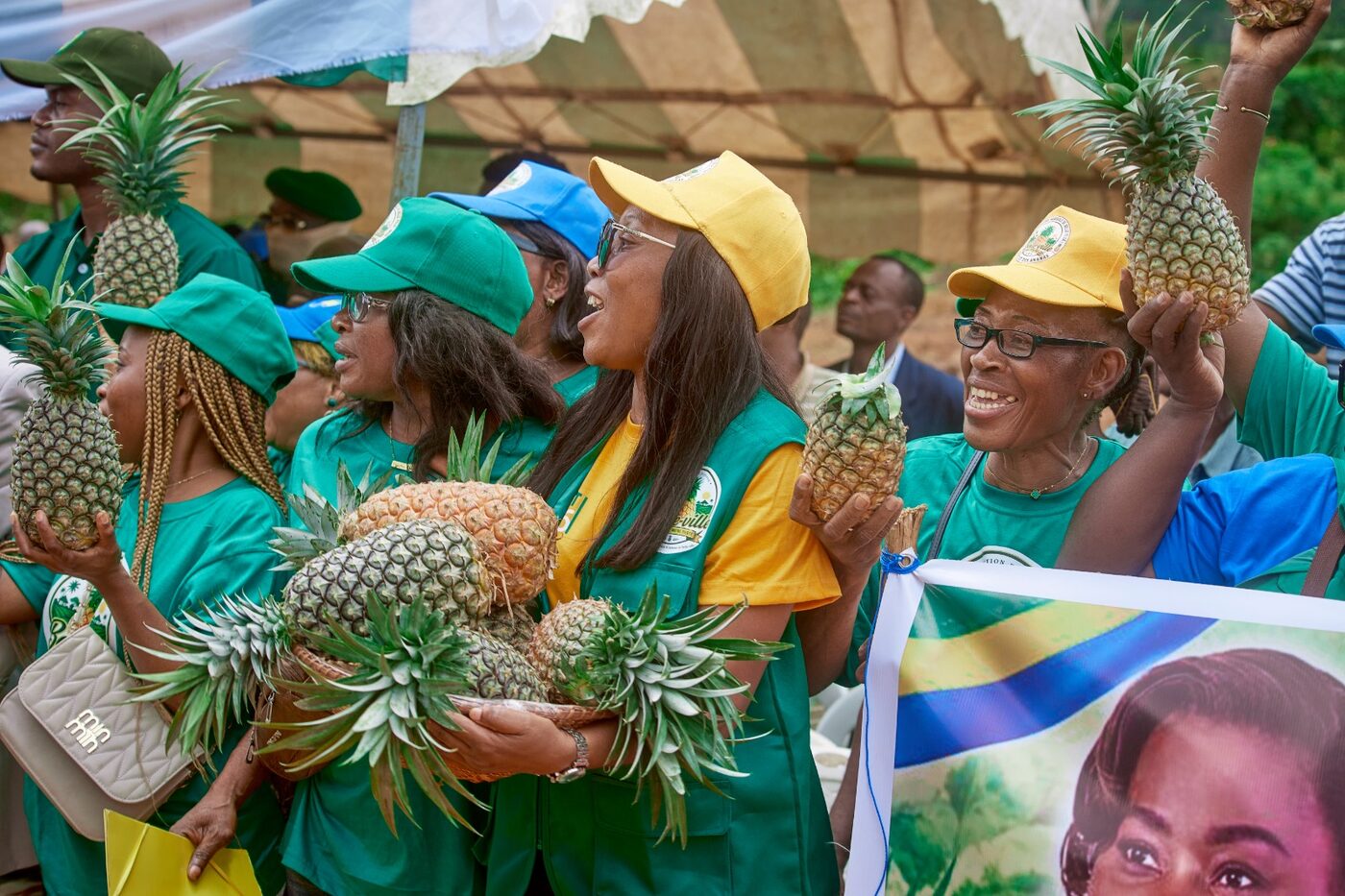 Femmes en t-shirts verts qui présentent des ananas
