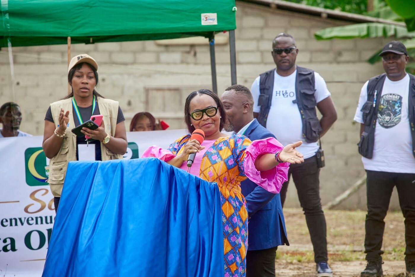Discours au pupitre devant une banderole de bienvenue