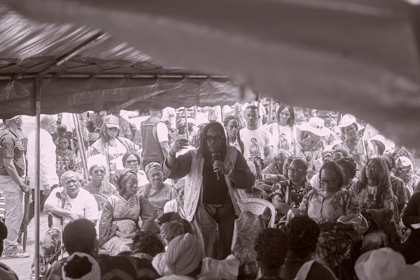 Foule réunie sous une grande tente, en noir et blanc