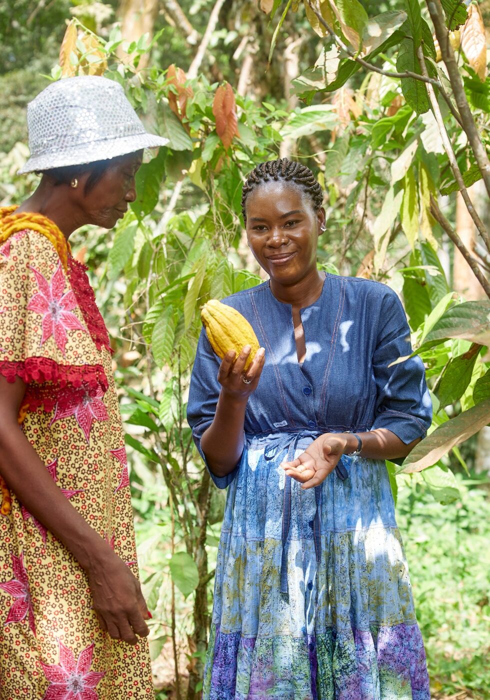 Une planteuse montre une cabosse de cacao dans sa plantation